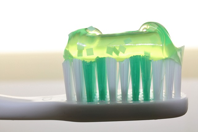 manuální zubní kartáček s nanesenou zubní pastou na svrchní části